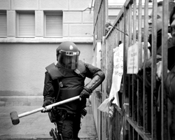 Полиция в черных доспехах и шлемах, избивающая безоружных людей (фото: Alain Pitton/ZUMA/Global Look Press)