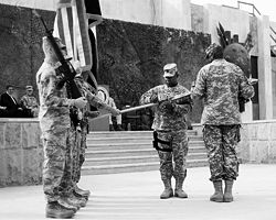 Офицер Джо Аллен (второй справа) и командующий американской армией в Ираке генерал Ллойд Остин складывают военные американские знамена в Багдаде (Фото: Reuters)