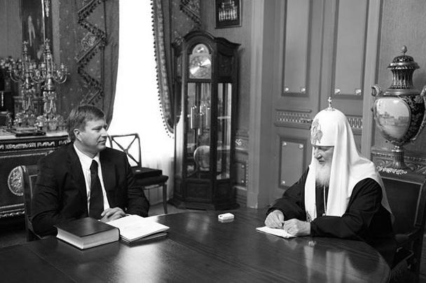 Пресс-служба патриарха Кирилла в четверг дала официальные объяснения по поводу подредактированного архивного снимка, где у священника на руке отсутствуют часы, отражающиеся в полировке стола