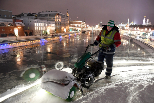 Сотрудник коммунальных служб во время уборки последствий снегопада в парке "Зарядье".