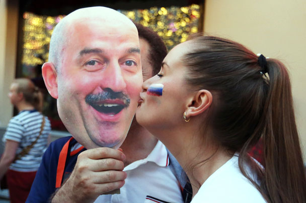 Болельщица сборной России целует маску с изображением главного тренера сборной России по футболу Станислава Черчесова