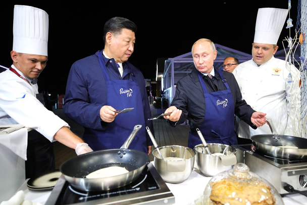 В выставочном павильоне «Русские морепродукты и русский рынок» Путин и Си Цзиньпин надели фартуки и приготовили блины