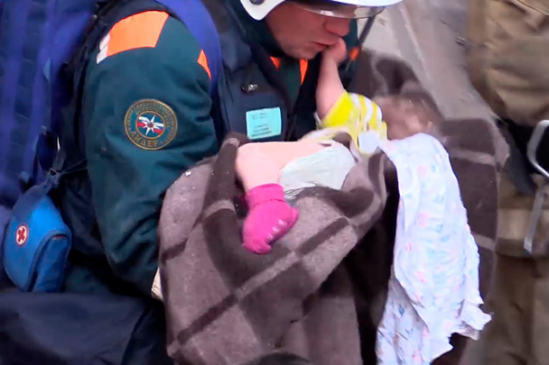Подполковник Петр Гриценко выносит младенца из-под завалов