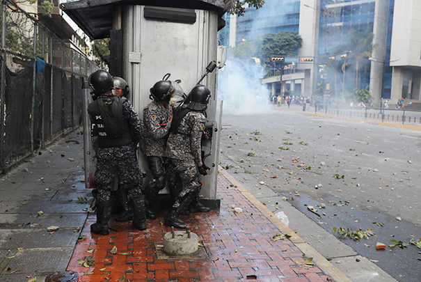 На некоторых улицах Каракаса идут настоящие бои, правоохранителям приходится укрываться от агрессии многотысячной толпы
