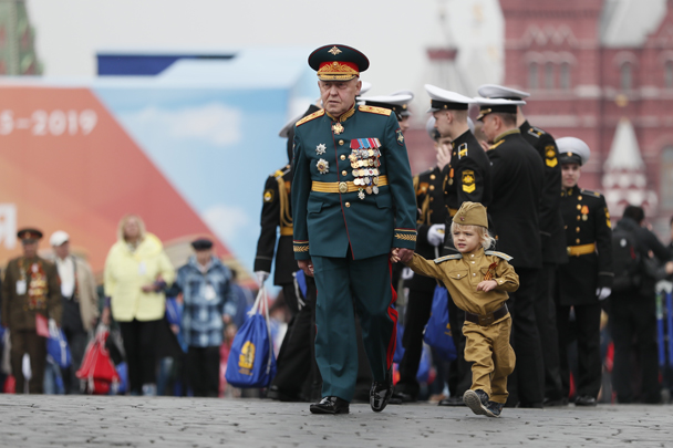 Ветеран вместе с ребенком гуляет после Парада Победы в Москве