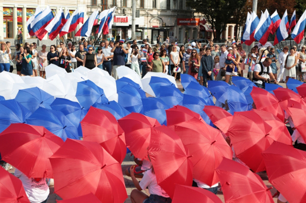 В Крыму в эти дни жарко и солнечно, но зонтики пригодились для флешмоба. В центре Симферополя из зонтов составили российский триколор