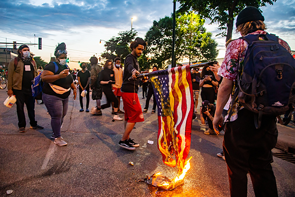 В окружении полиции протестующие сожгли американский флаг