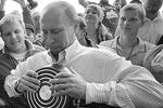 Один из членов «Русских богатырей» свернул в трубочку сразу две сковородки, которые подарил премьеру, сам Владимир Путин не стал портить новенькую сковородку&#160;(фото: РИА "Новости")