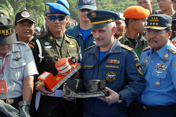 Руководитель оперативной группы МЧС РФ в Индонезии Михаил Чупаленков (в центре) продемонстрировал найденный речевой регистратор, который очень сильно обгорел