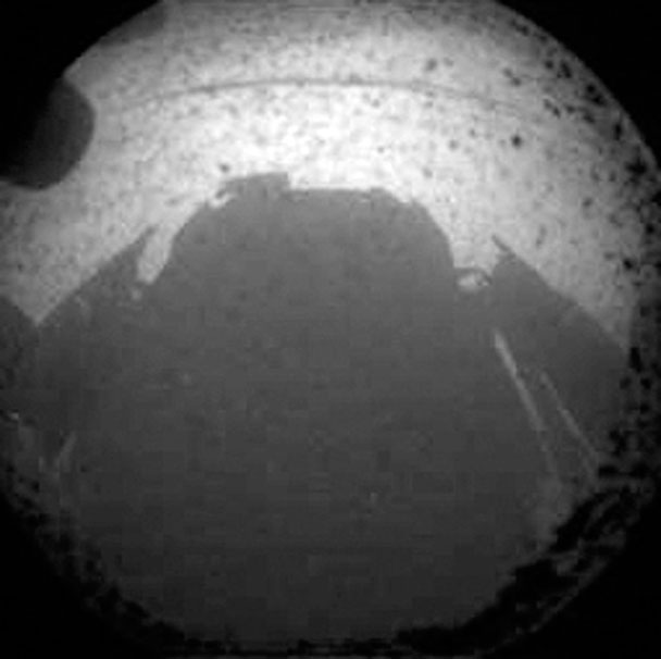 Из-за того, что камера установлена на задней части марсохода, в кадр попадает его тень