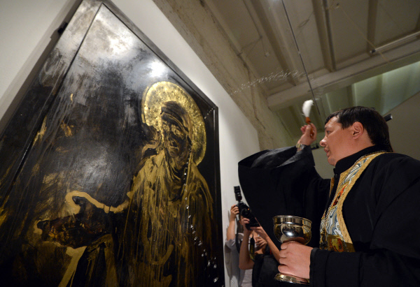 Священнослужитель освящает картину на открытии выставки «Духовная брань» в ЦСИ «Винзавод»