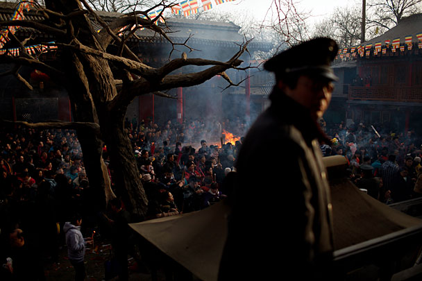 Прихожане курят фимиам во время молитвы о ниспослании удачи в первый день китайского Нового года в храме Угуаншан китайского города Ланжоу