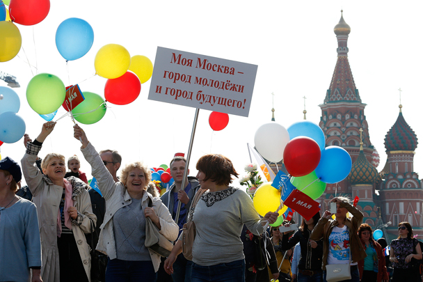 Участники шествия несли в руках плакаты, цветные шары и флажки с символикой праздника