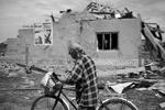 Местный житель проходит мимо разрушенного снарядом дома, пока спасатели ведут поиск уцелевших и подсчитывают ущерб и жертвы среди мирного населения&#160;(фото: ИТАР-ТАСС)