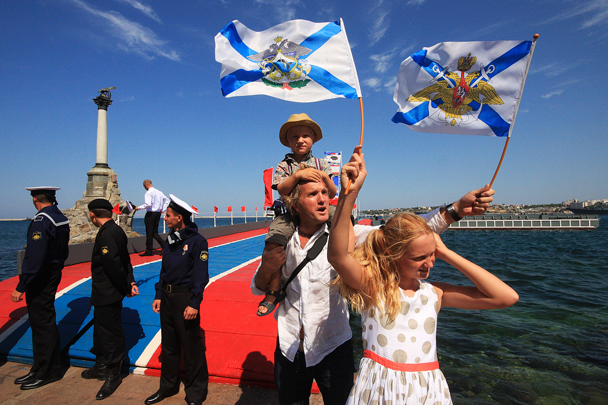 Зрители военно-морского парада в Севастополе с Андреевскими флагами