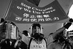 Полицейский держит плакат «Прекратите накалять обстановку, иначе мы применим силу» – официальное предупреждение властей Гонконга к протестующим&#160;(фото: EPA/ИТАР-ТАСС)