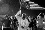 Чернокожие американцы протестуют с американским флагом&#160;(фото: Jeff Roberson/AP/ТАСС)