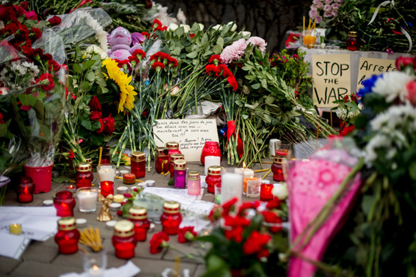 Многие несут к посольству цветы, свечи. Также люди оставили записки на разных языках с требованием остановить войну