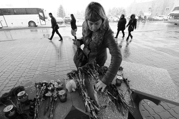 Женщина возлагает цветы у аэропорта Ростова-на-Дону, где при посадке разбился пассажирский самолет из Дубая