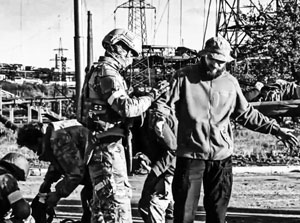 Российский солдат обыскивает сдающихся боевиков «Азова» 