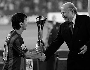 Лионель Месси получает главный приз клубного чемпионата мира из рук президента ФИФА Йозефа Блаттера