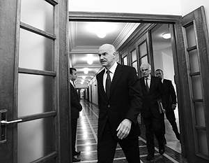 Председатель греческого правительства Папандреу выходит после совещания, на котором он  принял тяжелые условия ЕС и МВФ