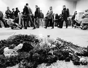Люди несут цветы к месту теракта в аэропорту Домодедово