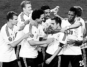 Футболисты Германии обнимают своего капитана Филиппа Лама, открывшего счет в игре с Грецией