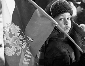 После того как на школах появятся флаги, детям будет проще объяснить, как отличить настоящий флаг России, – на фото мальчик с неправильным флагом страны
