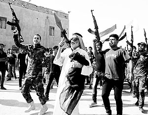 Волонтеры, присоединившиеся к иракской армии для борьбы с суннитскими боевиками, несут оружие во время парада на улицах Багдада 14 июня 2014 г.