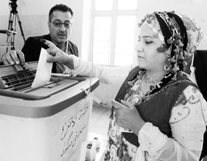 Голосующие курды находят свою фамилию в списке и ставят напротив отпечаток большого пальца, предварительно смазанного краской