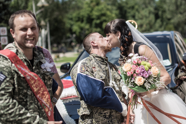 Один из самых известных ополченцев ДНР под позывным Моторола сыграл свадьбу в Донецке. Это первый официальный брак, заключенный в Новороссии. Торжество посетили первые лица республики, а белое платье невесты украшала кобура