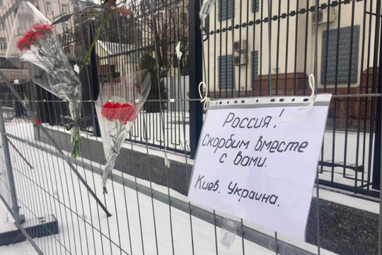 Украинцы несут цветы и свечи к российскому посольству в связи с крушением Ту-154