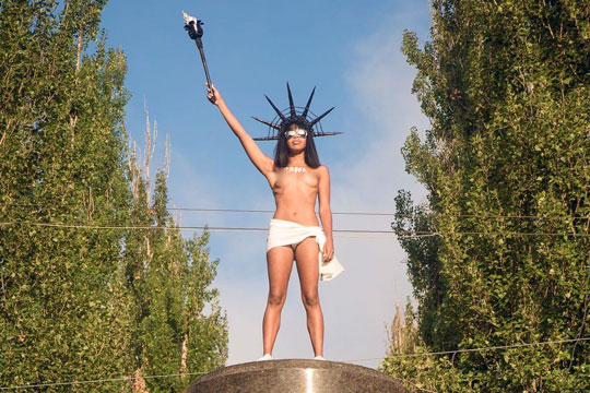 Голая активистка Femen бросалась конфетами Roshen с постамента памятника Ленину в Киеве